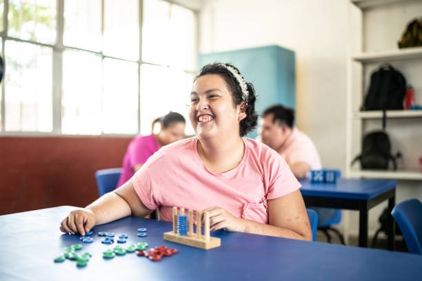 Psychomotor Intellectual disability teenage girl playing didactic game in the classroom at school